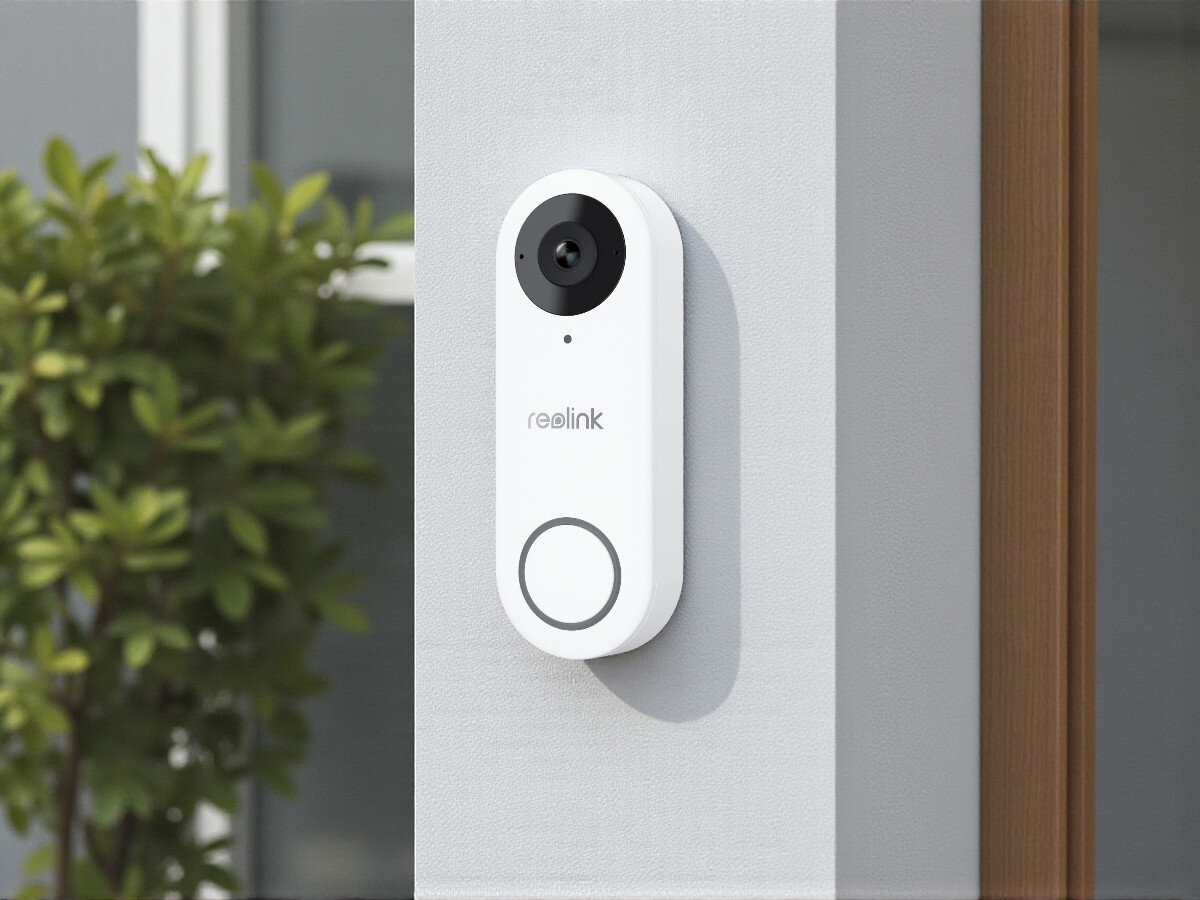 Wideodzwonek REOLINK D340W Bezprzewodowy Wi-Fi Biały, zdalny, stały, podgląd, kamera, Reolink D340W zamontowany przy wejściu, wyraźnie widoczny przycisk i obiektyw kamery, tło z zielenią.