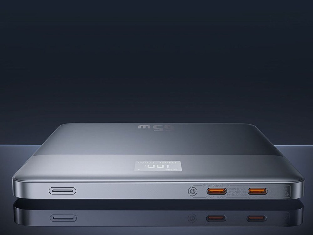 Srebrny powerbank Baseus Blade2 65W z wyświetlaczem 100%, zbliżenie na dwa porty USB-C i złącza boczne, ciemne tło