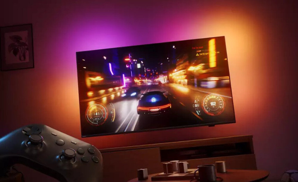 Telewizor PHILIPS 77OLED910 gaming HDMI 2.1 120 Hz VRR Game Bar 2.0 kontroler Bluetooth, telewizor wiszący na ścianie w pomieszczeniu, kontroler w tle