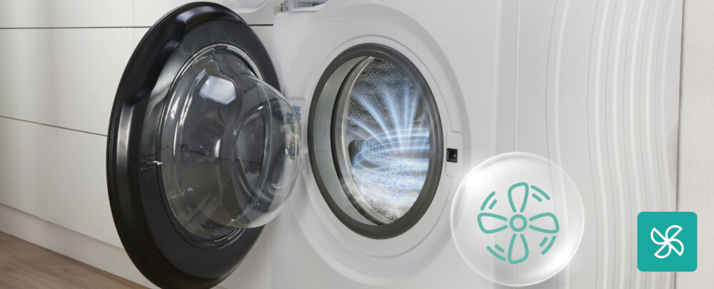 Pralko-suszarka GORENJE G600 WD2PA964ADT/PL Na zdjęciu widać otwarte drzwi białej pralki, a wewnątrz bębna zaznaczono graficznie delikatny przepływ powietrza symbolizujący wentylację lub odświeżanie wnętrza. Po prawej stronie umieszczono półprzezroczystą ikonę wiatraczka oraz turkusowy piktogram wentylatora, podkreślające funkcję przewietrzania bębna i ograniczania nieprzyjemnych zapachów AirDry suszenie higiena czystość resztki detergentów osady ograniczenie bakterii pleśń świeżość