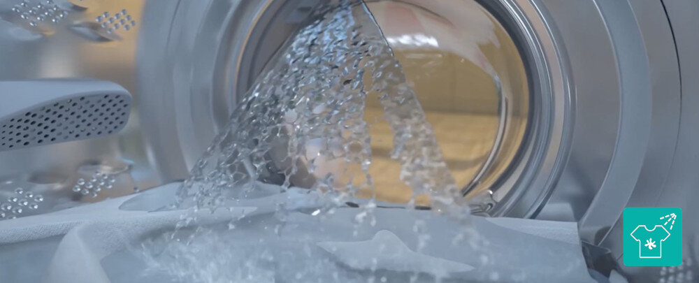 Pralko-suszarka GORENJE G600 WD2PA964ADT/PL Zbliżenie wnętrza bębna pokazuje silny strumień wody opadający na tkaniny, co podkreśla intensywne, ale delikatne pranie. W prawym dolnym rogu znajduje się turkusowa ikonka koszulki z gwiazdką i strumieniem wody, symbolizująca funkcję skutecznego usuwania plam natrysk wody skuteczne pranie usuwanie plam higiena bębna czysta uszczelka