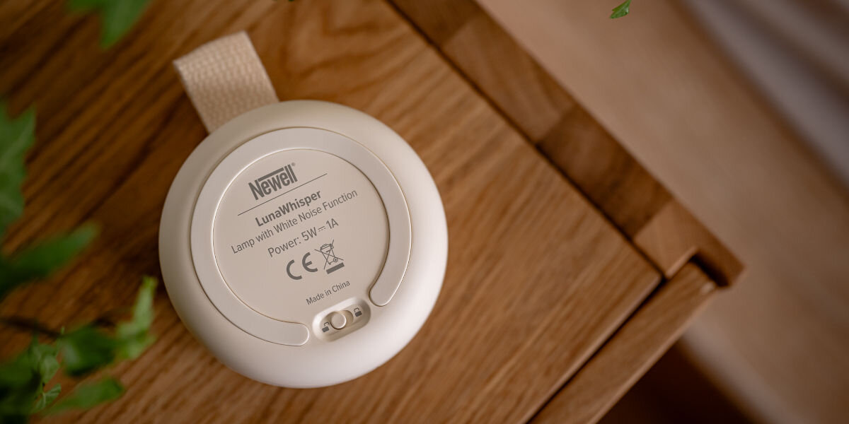 Lampka nocna LED NEWELL LunaWhisper NL4497, blokada, bezpieczeństwo, dzieci, kontrola, lampka od tylniej strony z zabezpieczeniem rodzicielskim leży na szafce