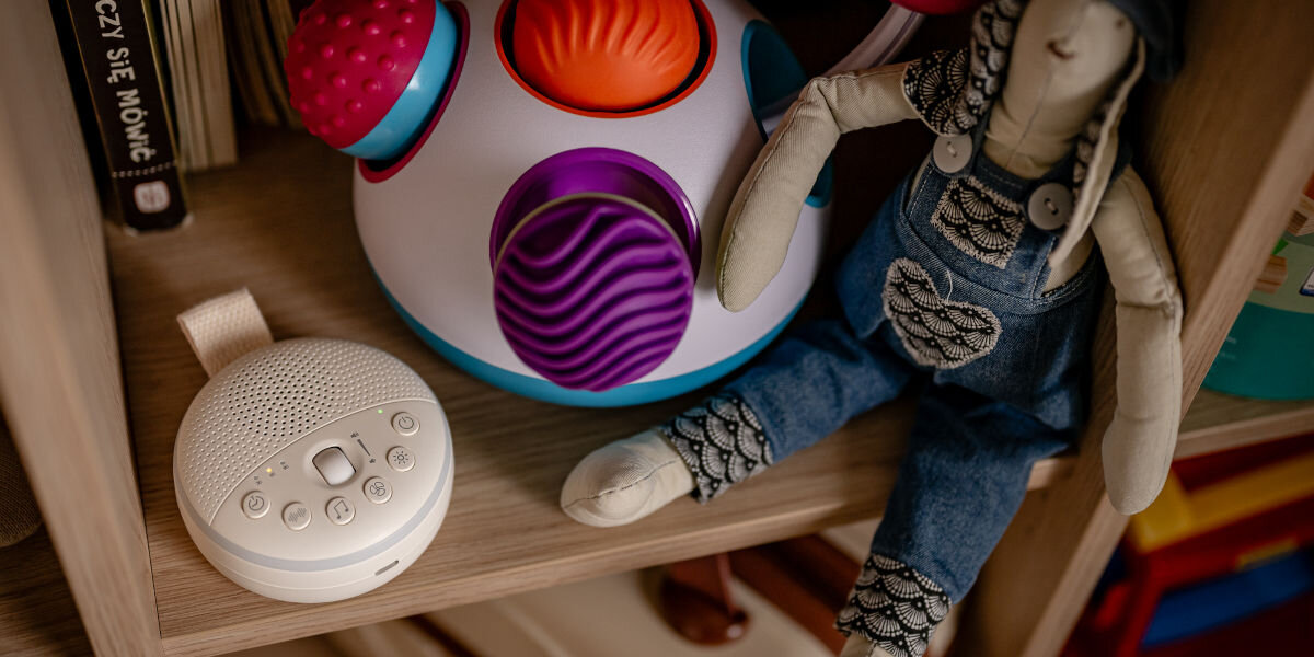 Lampka nocna LED NEWELL LunaWhisper NL4497, elegancja, USB-C, stabilność, funkcjonalność, lampka stoi na półce w towarzystwie maskotki, zabawki i książek