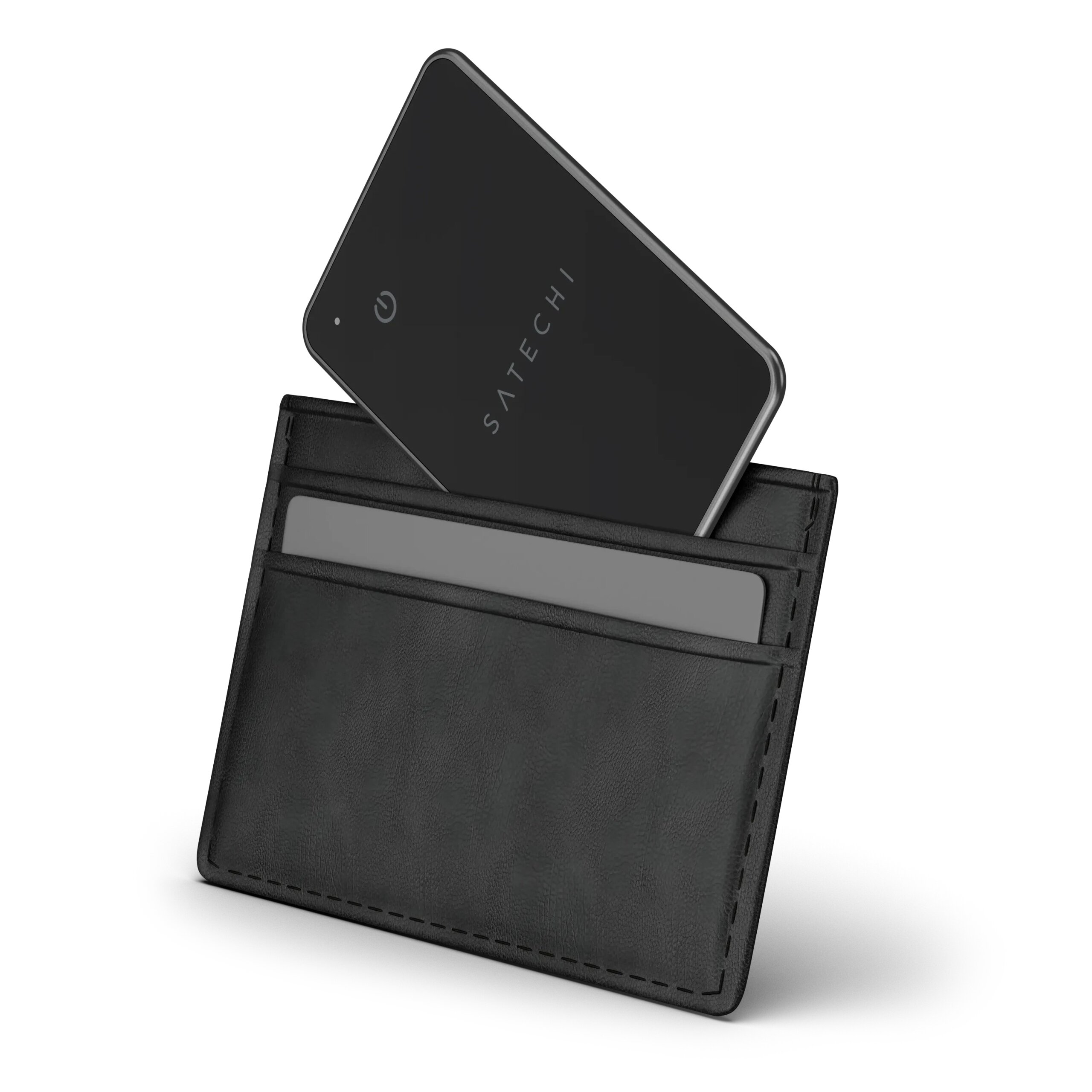 Czarny lokalizator z napisem \'SATECHI\' wystaje z czarnego etui na karty. Obok lokalizatora znajduje się szara karta w etui.