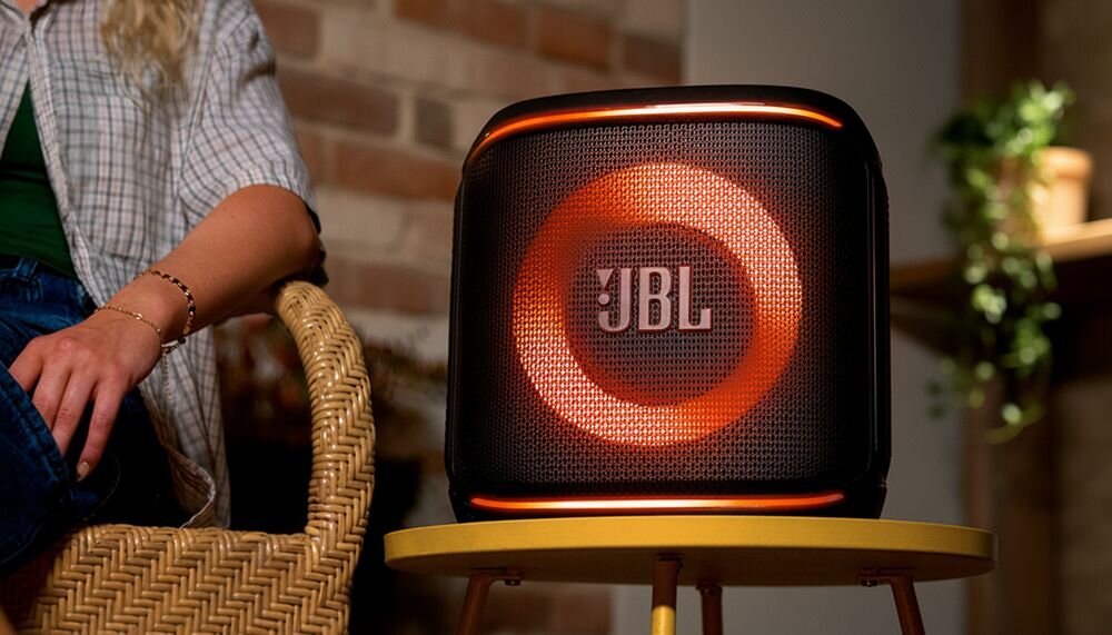 JBL PartyBox Encore Essential 2 power audio z mocnym brzmieniem i efektami świetlnymi, urządzenie na stoliku w pomieszczeniu