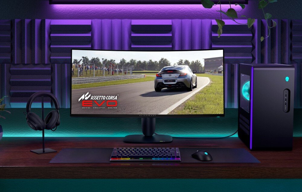 Monitor DELL Alienware AW3425DW Stanowisko komputerowe z monitorem wyświetlającym grę wyścigową oraz podświetlaną obudową komputera i akcesoriami