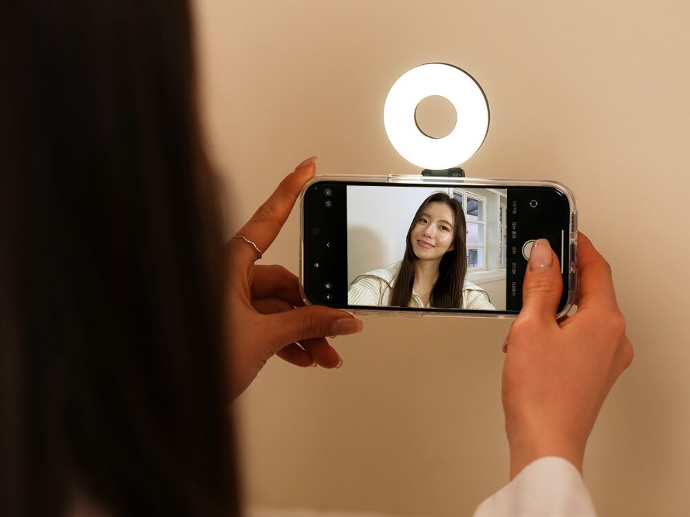 Lampa LED ARAREE Magfie Light MagSafe
            lampa zamontowana na telefonie z włączonym oświetleniem podczas robienia selfie
            kompaktowe wydajne akcesorium MagSafe łatwy montaż do urządzenia wyraźne oświetlenie odpowiednie światło do robienia zdjęć nagrywanie filmów transmisje na żywo