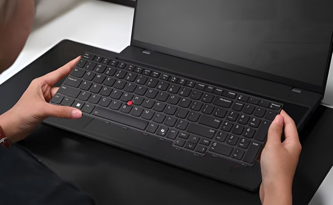 Osoba unosi klawiaturę laptopa LENOVO ThinkPad L16 Gen 2 prezentując modułową konstrukcję CRU – wymiana RAM SSD baterii przez dział IT