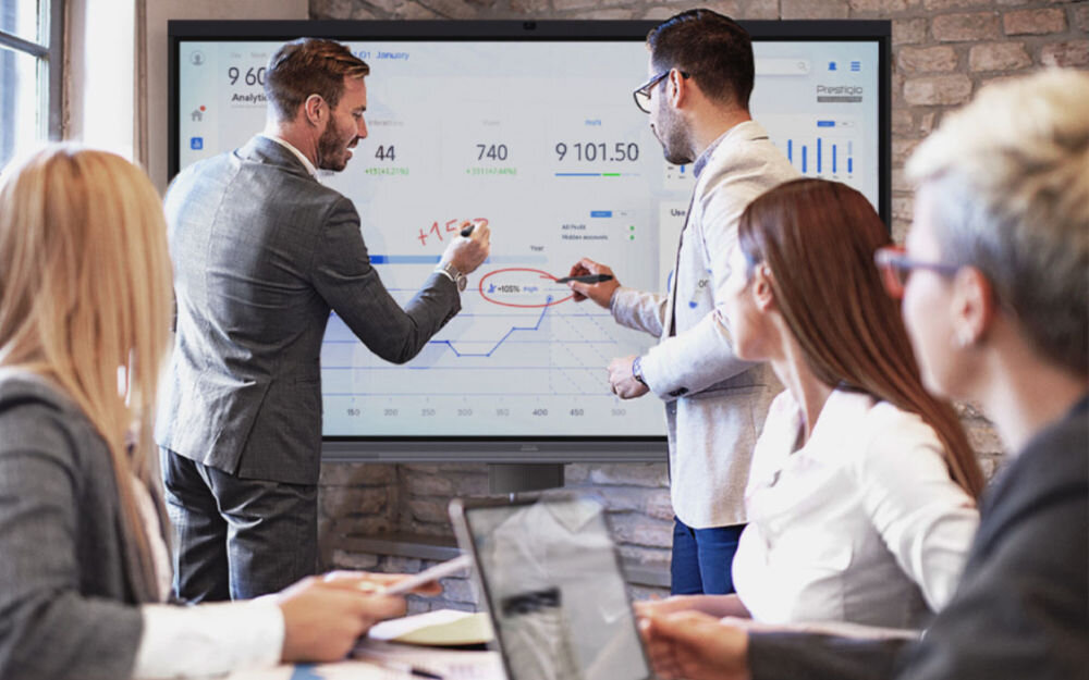 Monitor PRESTIGIO SOLUTIONS PSMB068P750 75 cali 3840x2160px IPS pokazanie monitora podczas pracy spotkanie biznesowe mężczyźni korzystający z monitora dotyk 40 punktów obsługa gestów współpraca interaktywna warsztaty zajęcia praca w grupach przyspieszenie pracy