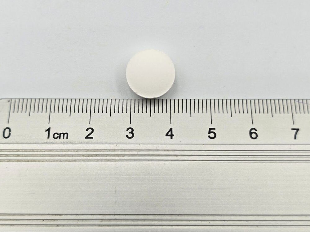 Suplement dla psa GAME DOG HMB (120 kapsułek) Makro zbliżenie na pojedynczą beżową kapsułkę suplementu Flora Protect, umieszczoną na podziałce linijki. Kapsułka mierzy około 2 cm długości (od znacznika 8 do 10 cm).