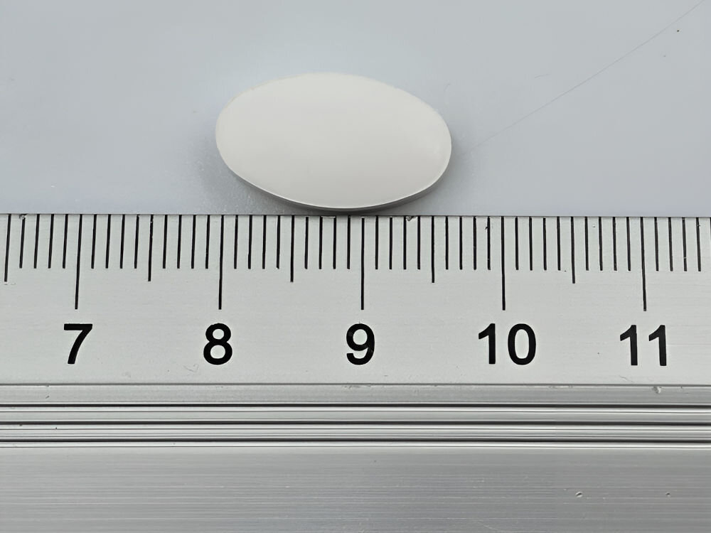 Suplement dla psa GAME DOG Calcium V2 (60 kapsułek) Zbliżenie na owalną, białą tabletkę suplementu GameDog dla psa, mierzoną na linijce (rozmiar około 2 cm).