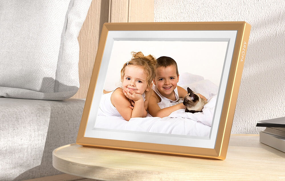 Ramka cyfrowa ARZOPA D10 10.1 cala Złoty prezentacja ramki ze zdjęciem dzieci i kota na szafce nocnej obok łóżko ekran rozdzielczość format wyrazistość naturalne kolory przytulna atmosfera