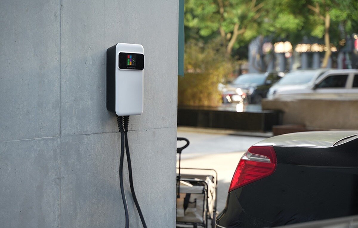 Ładowarka do samochodu elektrycznego BESEN SQ20 App 22 kW Ścienna stacja ładowania pojazdów elektrycznych z kolorowym ekranem LCD zamontowana na betonowej ścianie.