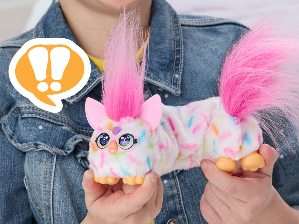 Maskotka HASBRO Furby DJ Furblets Berry-Cup-Cake G17815X0 Dziecko trzyma w dłoniach pluszową zabawkę Furby Furblets Berry-cup-cake w kolorze białym z kolorową posypką i różową czupryną.