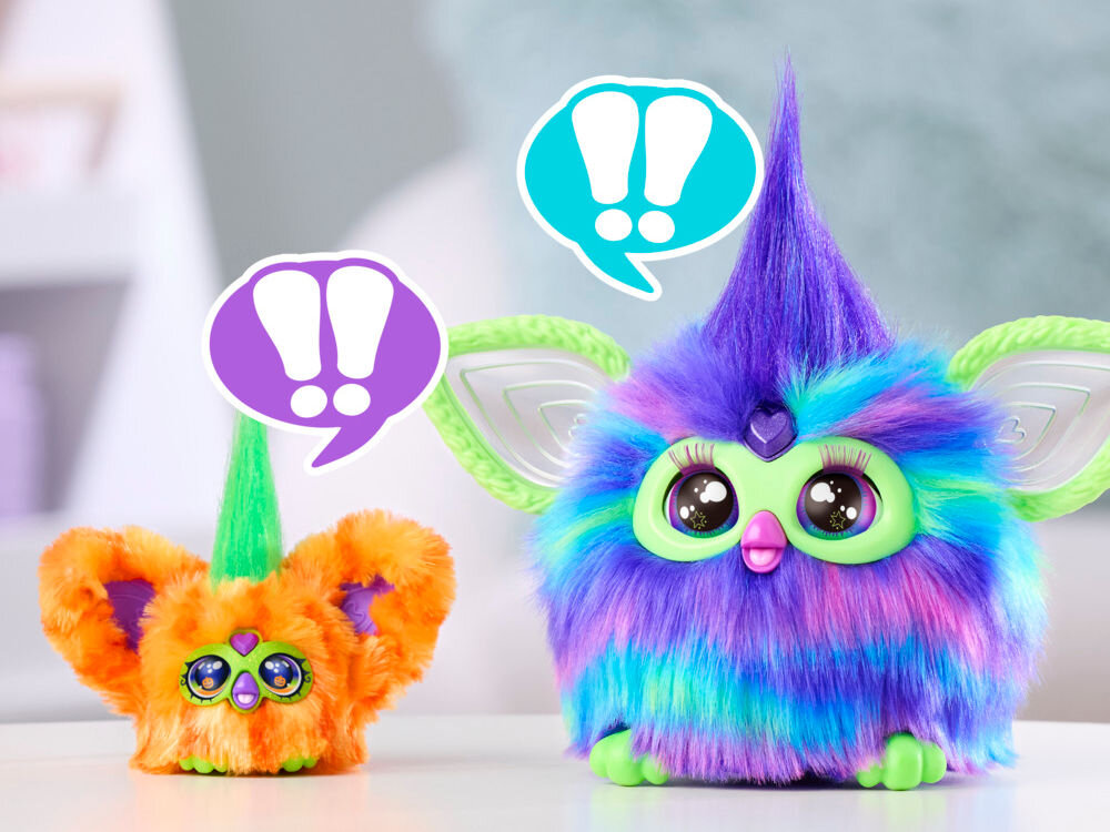 Maskotka HASBRO Furby Furbisie Boo-Kin G14355D0 Porównanie wielkości dwóch interaktywnych zabawek: małej maskotki Furby Furblets oraz dużego, fioletowo-niebieskiego Furby. Nad obiema postaciami widoczne są dymki z wykrzyknikami, co wskazuje na ich zdolność do wzajemnej komunikacji.
