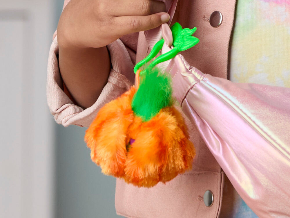 Maskotka HASBRO Furby Furbisie Boo-Kin G14355D0 Pomarańczowa maskotka Furby Furblets przypięta za pomocą zielonego klipsa do kieszeni różowej kurtki dziecka, prezentująca zabawkę jako brelok do plecaka lub ubrania.