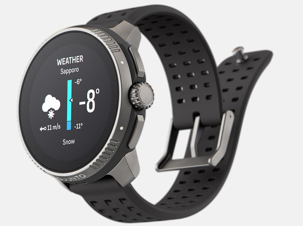 Smartwatch z okrągłym wyświetlaczem pokazuje prognozę pogody dla Sapporo: -8 stopni, śnieg, wiatr 11 m/s. Pasek zegarka jest czarny z perforacjami, a obudowa ma metaliczne wykończenie.