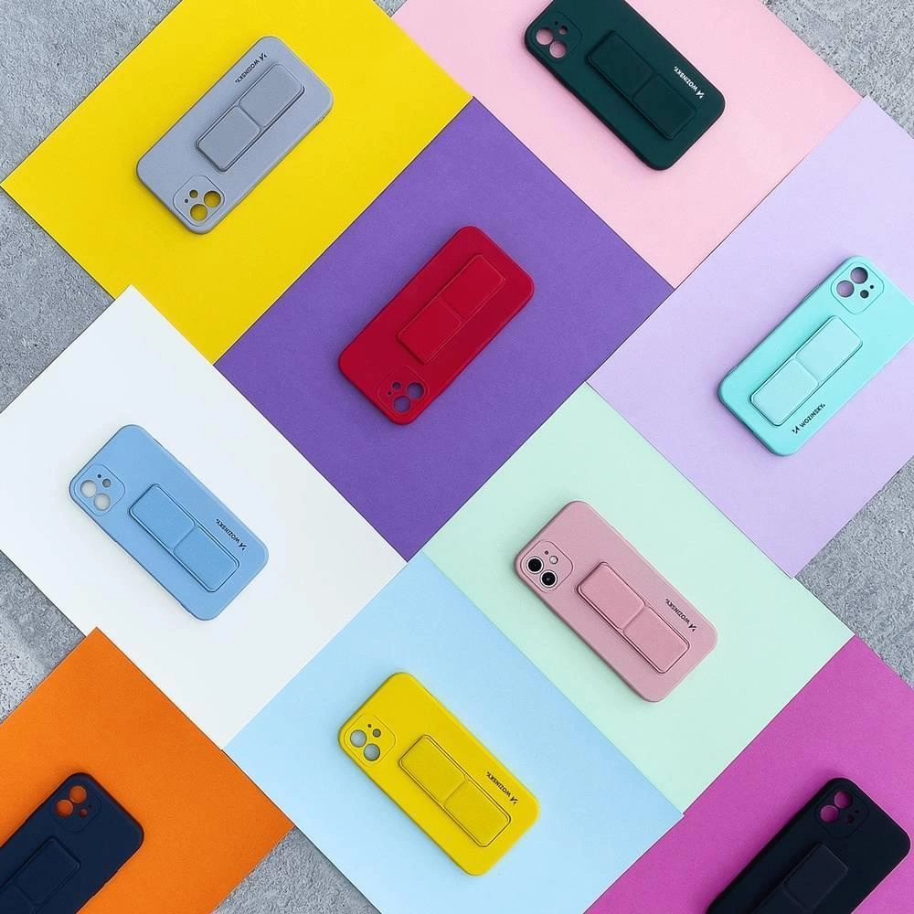 Na obrazie widać różnokolorowe etui na telefon z podstawką, ułożone na kolorowych kartkach papieru. Na niektórych etui widoczny jest napis \'Wozinsky\'.