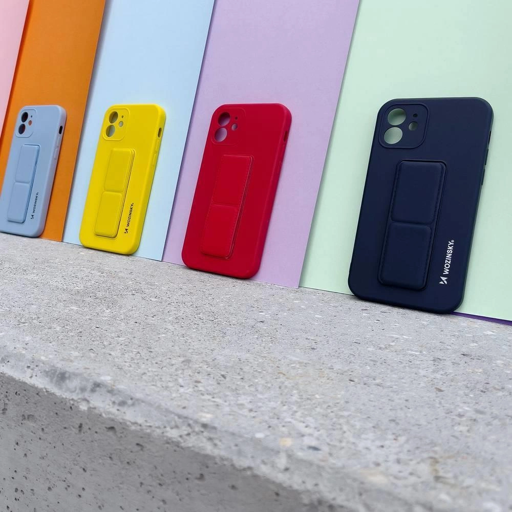 Cztery kolorowe etui na telefon z podstawką ustawione na betonowej powierzchni, każde z logo \'Wozinsky\'.