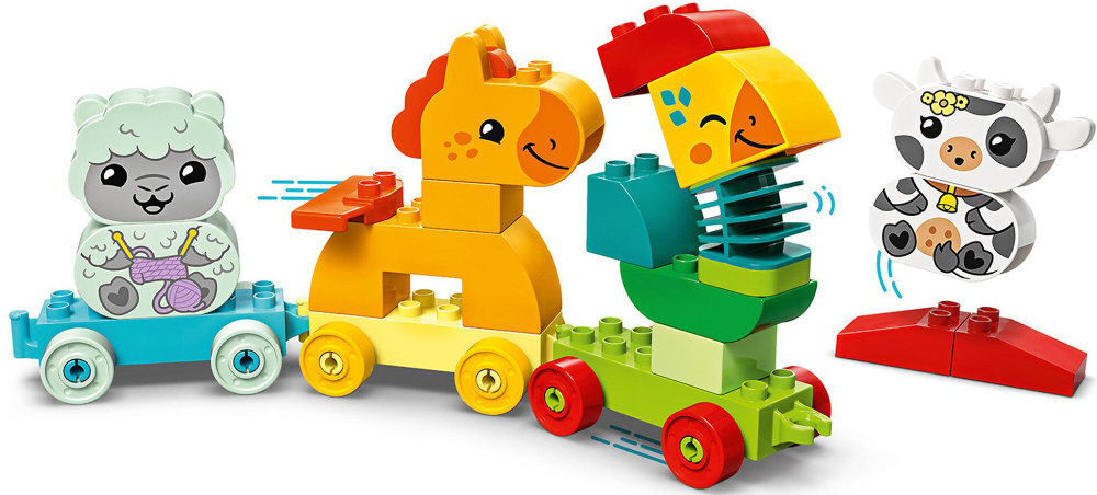 Zestaw klocków LEGO przedstawiający kolorowy pociąg z trzema wagonikami, na których znajdują się zwierzątka: owca, koń i papuga. Obok pociągu widoczna jest krowa na czerwonej podstawce.