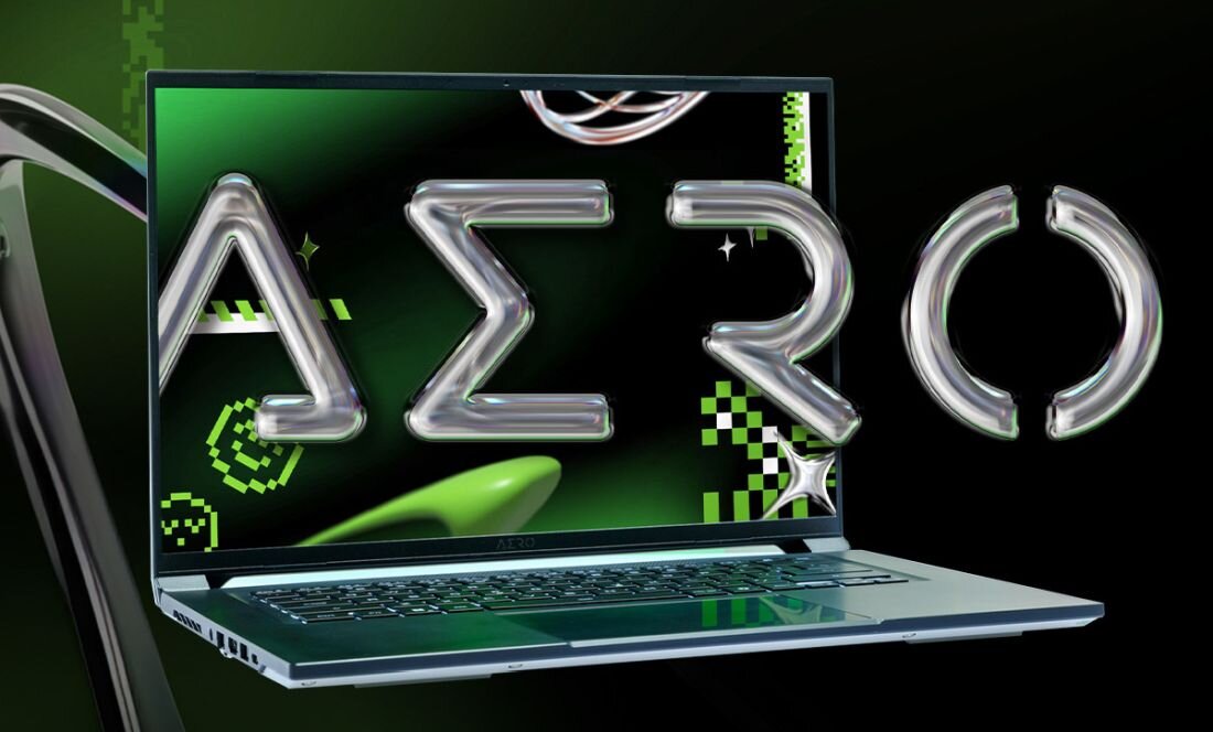 Laptop z wyświetlaczem pokazującym grafikę z napisem \'AERO\' w stylu futurystycznym. Tło jest zielono-czarne z elementami graficznymi przypominającymi piksele i kształty geometryczne.