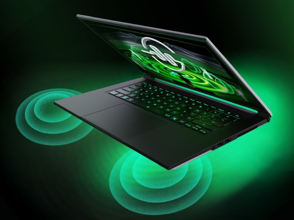 Laptop z podświetlaną klawiaturą i ekranem wyświetlającym zielone wzory. W tle widoczne są zielone efekty świetlne.