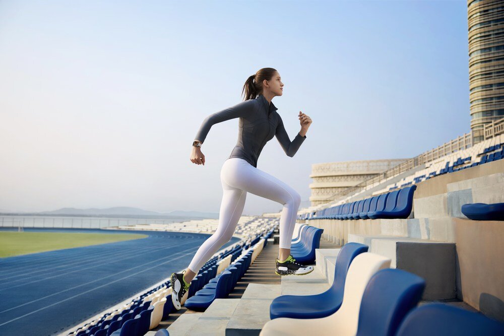 Smartwatch HUAWEI Watch Fit 4 kobieta biega po schodach  