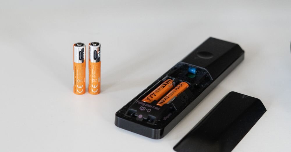 Akumulatorki AAA 570 mAh XTORM XNG3AB4 (4 szt.), bateria, ładowanie, oszczędność, zasilanie, baterie stoją na blacie w parze oraz wpięte do gniazda pilota do tv