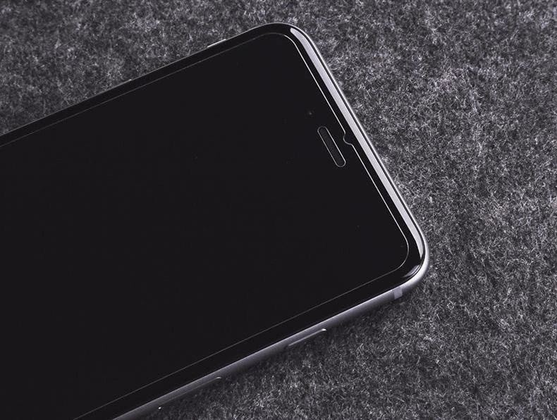 Na obrazie widoczny jest smartfon z ciemnym ekranem, leżący na szarej powierzchni. Ekran jest gładki i błyszczący, bez widocznych uszkodzeń.