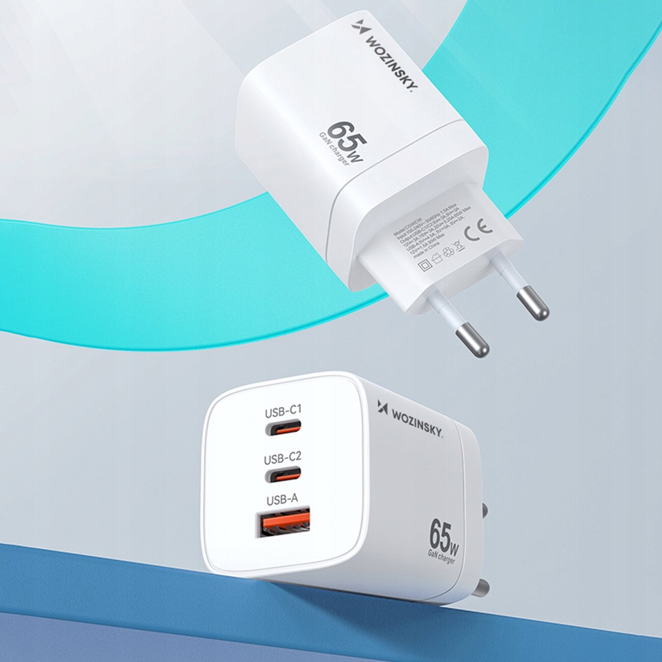 Na obrazie widoczna jest biała ładowarka sieciowa z trzema portami: USB-C1, USB-C2 i USB-A. Na ładowarce znajduje się napis \'WOZINSKY 65W GaN charger\'.