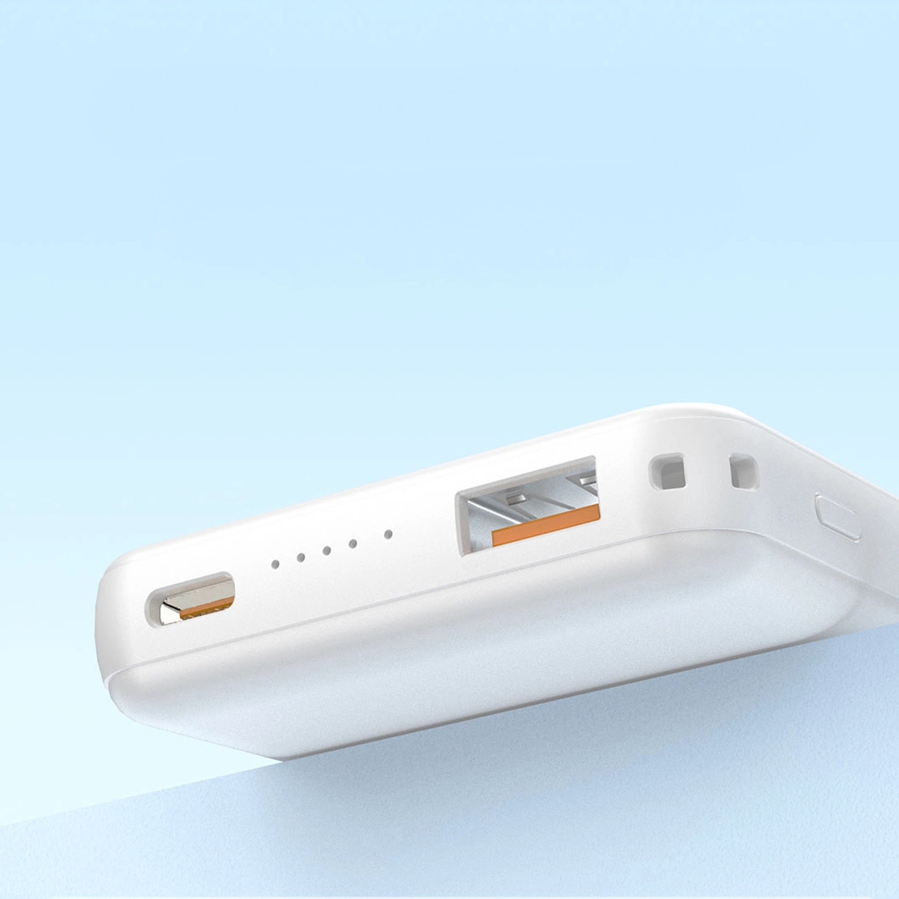 Biały powerbank z widocznymi portami USB-A i USB-C oraz wskaźnikami LED na obudowie. Produkt jest umieszczony na jasnym tle.
