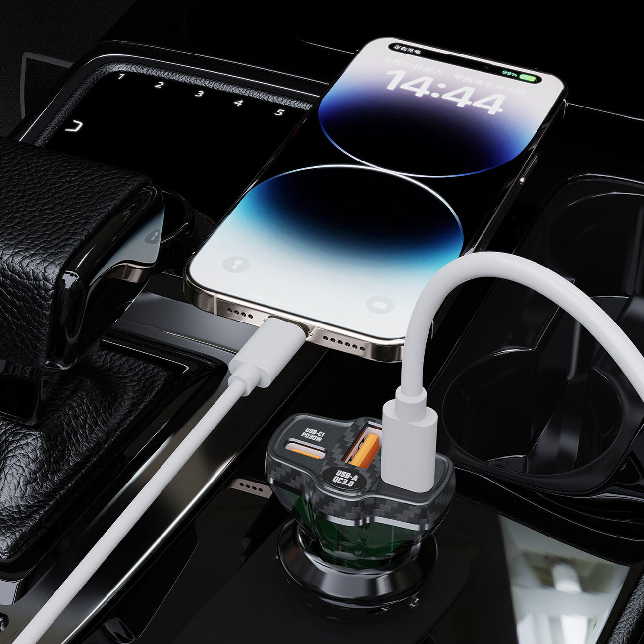 Na zdjęciu widać czarną ładowarkę samochodową z dwoma portami USB-A i jednym USB-C, podłączoną do gniazda w samochodzie. Obok leży smartfon z wyświetlonym czasem 14:44, podłączony do ładowarki za pomocą białego kabla.
