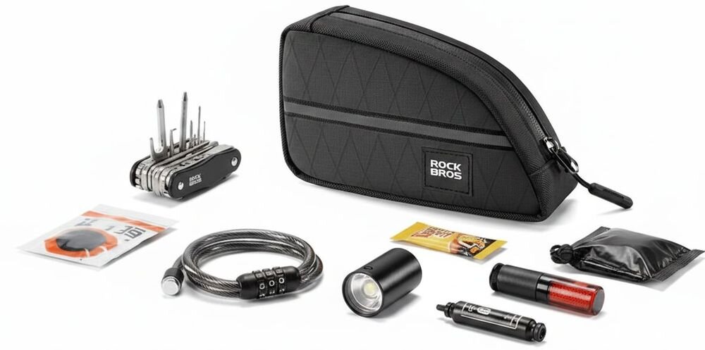 Na obrazie widoczna jest czarna torba rowerowa z logo \'ROCKBROS\', otoczona różnymi akcesoriami rowerowymi, takimi jak zestaw narzędzi, zamek na klucz, latarka i inne drobne przedmioty.