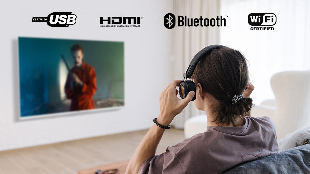 Telewizor JVC LT-32VQF55DW - HDMI z ARC i Bluetooth, kobieta oglądająca program w telewizji z nałożonymi słuchawkami, Dwa złącza HDMI, ARC, internet