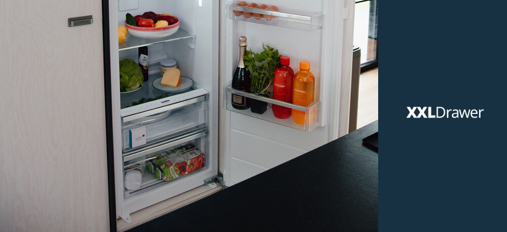 LODÓWKA VESTFROST VR-BF27953H0S Na zdjęciu widoczna jest otwarta chłodziarka do zabudowy Vestfrost, w której dolną część zajmują bardzo pojemne szuflady na warzywa, owoce i napoje. Po prawej stronie, na granatowym tle, znajduje się napis „XXLDrawer”, podkreślający zwiększoną pojemność tych szuflad funkcjonalne wnętrze lodówki półki drzwiowe szuflada XXL listwy inox wygodne przechowywanie