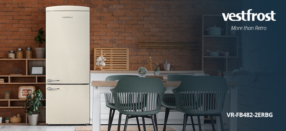 Lodówka VESTFROST VR-FB482-2ERBG No Frost 190.1cm Beżowy Na zdjęciu widać kremową lodówkę retro w stylowej kuchni z ceglanym tłem i stołem otoczonym zielonymi krzesłami.