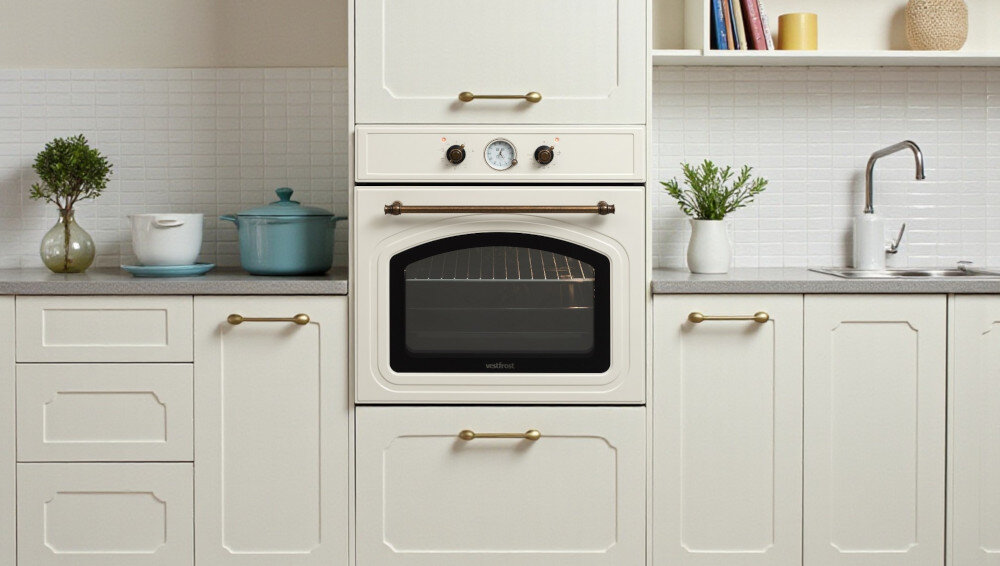 Piekarnik VESTFROST VO-65W19MAVMC Zdjęcie 2 ukazuje jasną, elegancką kuchnię ze sprzętem w zabudowie — piekarnikiem Vestfrost, białymi frontami, dekoracyjną roślinnością i minimalistycznym wystrojem styl retro chrowanene detalr estetyka wygląd funkcjonalność