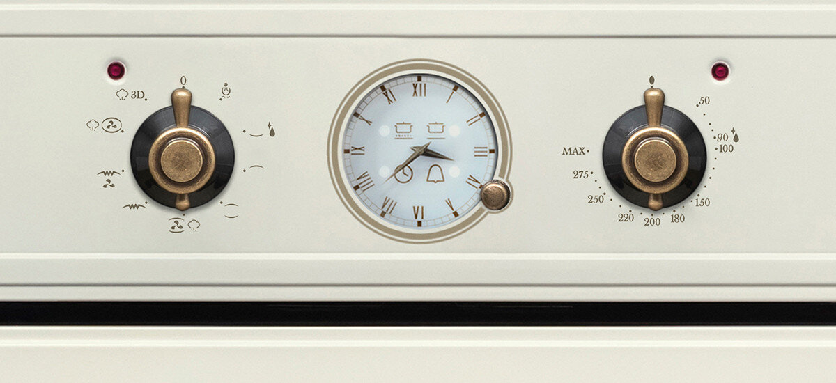 Piekarnik VESTFROST VO-65W19MAVMC Pokazuje zbliżenie na stylowy panel piekarnika Vestfrost z analogowym zegarem oraz dekoracyjnymi wykończeniami w kolorze starego złota. zegar analogowy retro zegar mechaniczny sterowanie piekarnikiem pokrętła retro