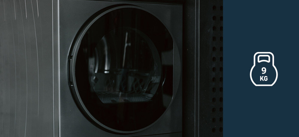 Suszarka VESTFROST VT-FD42HN90EU Na zdjęciu znajduje się suszarka bębnowa Vestfrost w ciemnym kolorze, przedstawiona z bliska na tle ciemnej ściany. Po prawej stronie grafika informuje o maksymalnej pojemności urządzenia wynoszącej 9 kg kompaktowa do mieszkania do małej łazienki slim 45 cm dla małej rodziny Vestfrost 9 kg