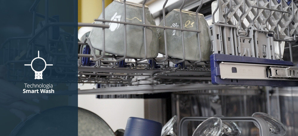 Zmywarka VESTFROST VD-S39B60Q140 Zdjęcie przedstawia wysunięty górny kosz zmywarki Vestfrost z ustawionymi filiżankami i sztućcami, sfotografowany z boku w zbliżeniu. Po lewej stronie, na przyciemnionym tle, znajduje się ikonka spryskiwacza oraz napis „Technologia Smart Wash”, podkreślający automatyczne dopasowanie parametrów zmywania do stopnia zabrudzenia naczyń technologia Smart Wash czujnik zmętnienia wody automatyczne dopasowanie cyklu oszczędność energii oszczędność wody inteligentne mycie