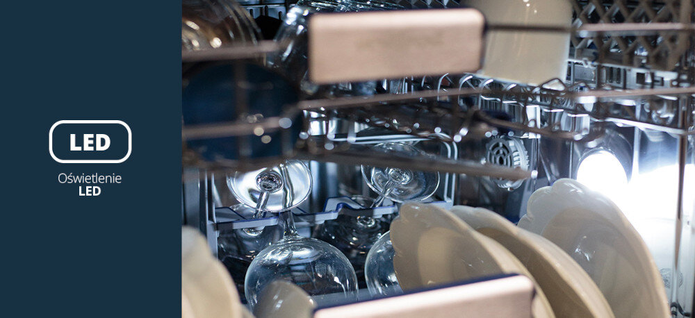Zmywarka VESTFROST VD-S39B60Q140 Zdjęcie przedstawia wnętrze pracującej zmywarki Vestfrost, wypełnione kieliszkami i talerzami, doświetlone jasnym światłem bocznej listwy LED. Po lewej stronie, na granatowym tle, widnieje biały napis „LED Oświetlenie LED”, podkreślający wygodne, energooszczędne podświetlenie komory ułatwiające załadunek i kontrolę naczyń oświetlenie LED wnętrze urządzenia dobra widoczność łatwy załadunek nowoczesna estetyka funkcjonalne podświetlenie