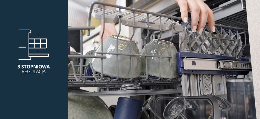 Zmywarka VESTFROST VD-S39B60Q140 Zdjęcie przedstawia górny kosz zmywarki Vestfrost z ustawionymi filiżankami, który użytkownik podnosi lub opuszcza, chwytając za boczny uchwyt prowadnicy. Po lewej stronie, na granatowym tle, widnieje ikonka profilu z koszem oraz napis „3 STOPNIOWA REGULACJA”, informujący o trzystopniowej regulacji wysokości kosza dla lepszego dopasowania przestrzeni do naczyń regulowany kosz 3 stopnie wysokości elastyczne wnętrze wysokie garnki duże talerze stabilne ułożenie naczyń