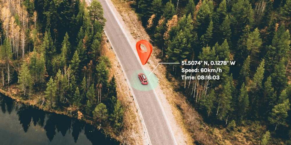Zdjęcie przedstawia samochód na drodze otoczonej lasem, z widocznym wskaźnikiem lokalizacji GPS. Obok samochodu znajduje się tekst: \'51.5074° N, 0.1278° W, Speed: 60km/h, Time: 08:16:03\'.