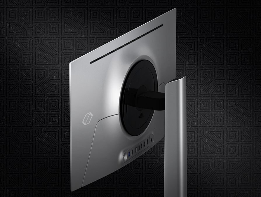 Widok z tyłu monitora z okrągłą podstawą i prostokątnym panelem. Na obudowie widoczne są porty oraz logo producenta.