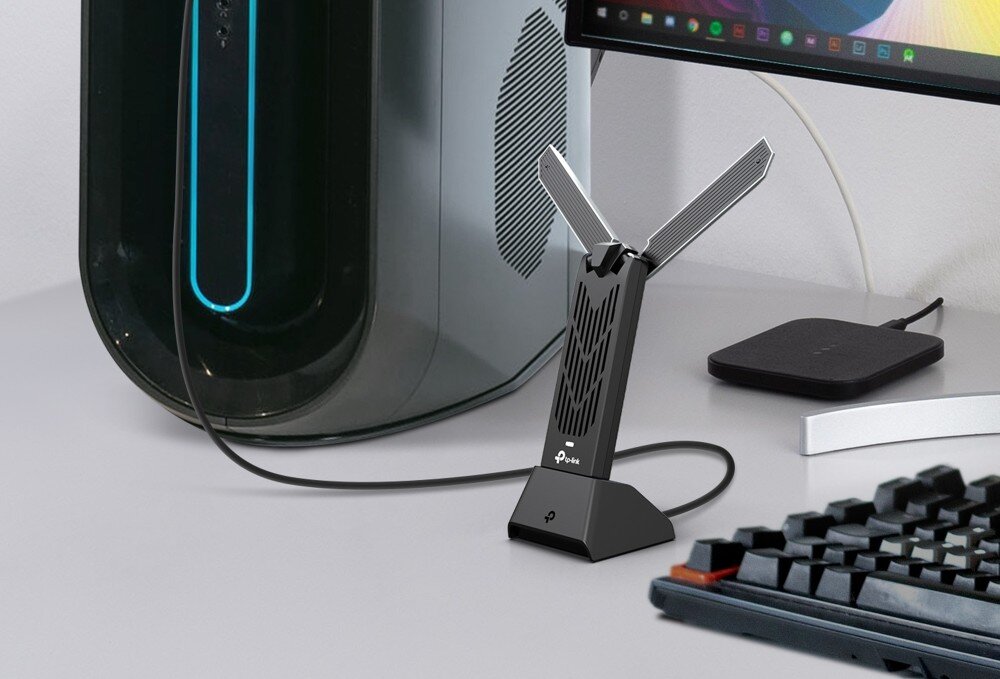 Karta sieciowa TP-LINK Archer TBE400UH Karta sieciowa stojąca na biurku obok komputera, monitora i klawiatury, szyfrowanie, zabezpieczenia