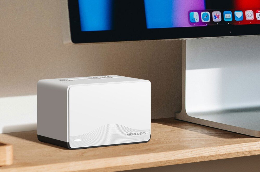 Router MERCUSYS Halo H27BE Urządzenie sieciowe umieszczone na drewnianym blacie biurka pod monitorem komputerowym, obsługa urządzeń