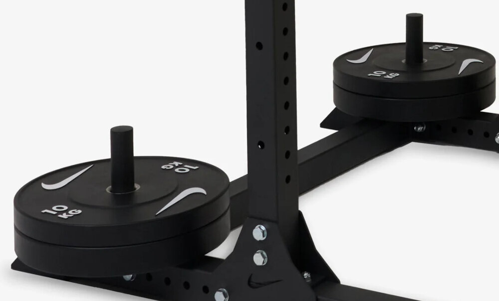 Stojak pod sztangę NIKE Squat Rack zbliżenie na uchwyty na sztangi uchwyty na talerze obciążeniowe szybki dostęp podczas zmiany obciążenia porządek w strefie ćwiczeń
