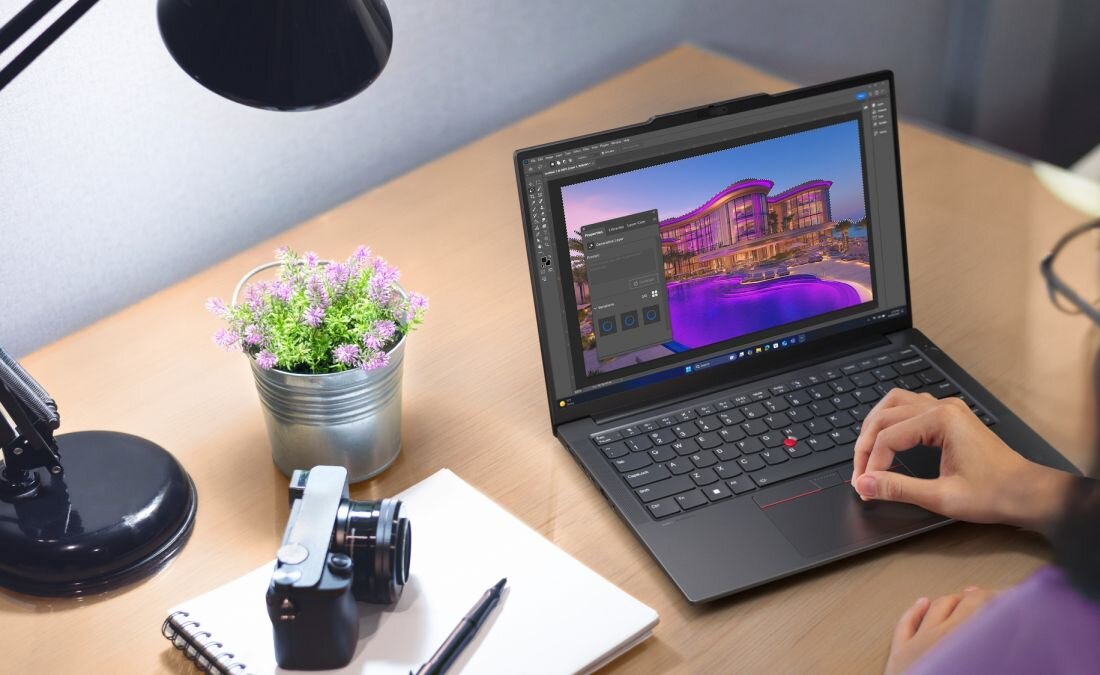 Osoba edytuje zdjęcie na laptopie Lenovo ThinkPad E14 Gen 7 z łącznością Wi-Fi 6E przy biurku z aparatem i notatnikiem - Wi-Fi 6E i Bluetooth 5.3