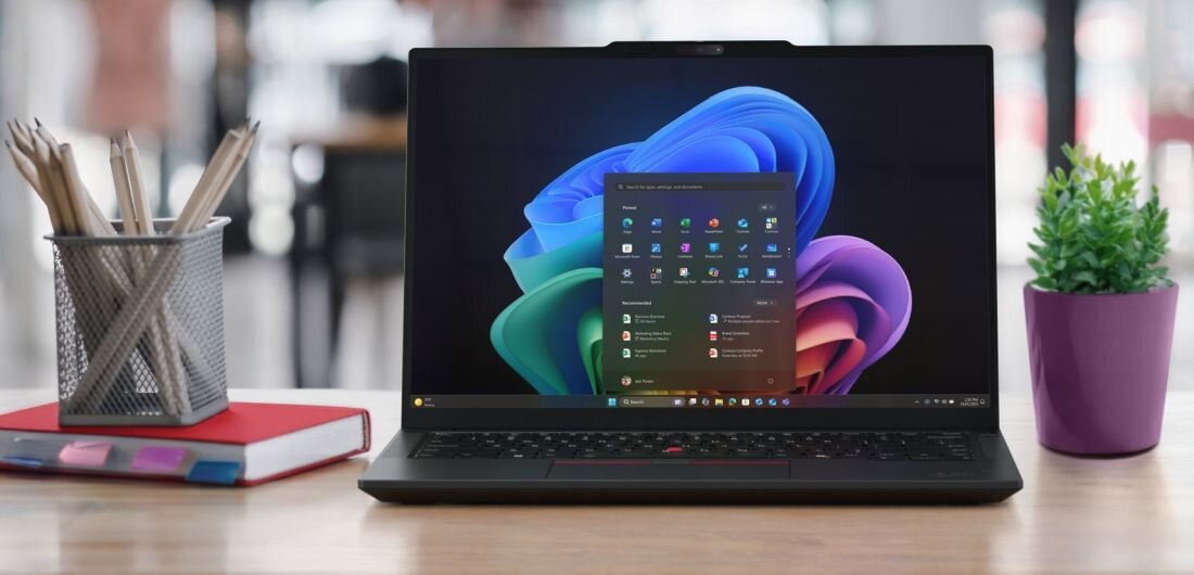Laptop Lenovo ThinkPad E14 Gen 7 z procesorem Intel Core Ultra 7 255H stoi na biurku obok notatników i rośliny w przestrzeni biurowej