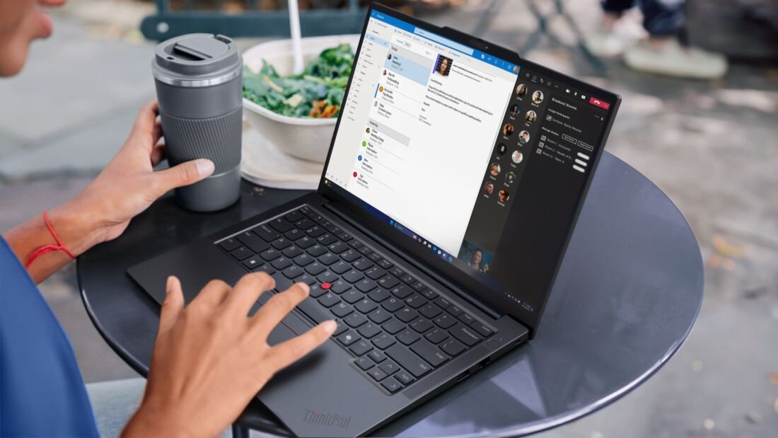 Osoba korzysta z laptopa Lenovo ThinkPad E14 Gen 7 z wygodną klawiaturą podczas pracy przy stoliku w kawiarni - Klawiatura ThinkPad z TrackPointem